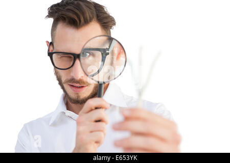 Nerdy businessman looking through magnifying glass Stock Photo