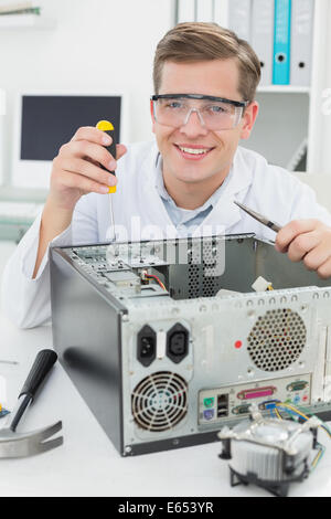 Happy  computer engineer working on broken device Stock Photo