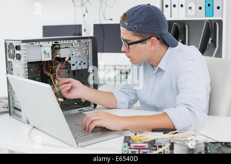 Computer engineer working on broken console with laptop Stock Photo