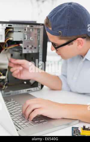 Computer engineer working on broken console with laptop Stock Photo