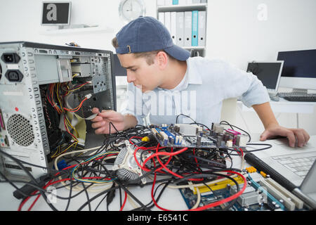 Computer engineer working on broken console with laptop Stock Photo