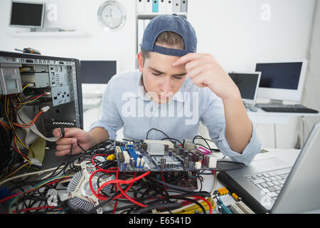 Computer engineer working on broken console with laptop Stock Photo
