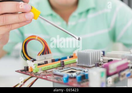 Technician working on broken cpu with screwdriver Stock Photo