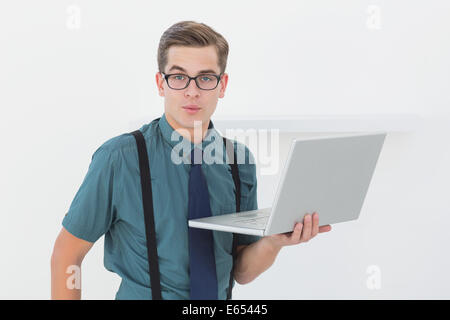 Nerdy businessman holding laptop looking at camera Stock Photo