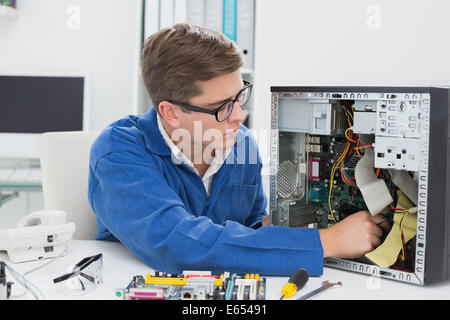 Young technician working on broken computer Stock Photo