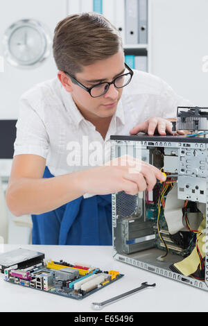 Young technician working on broken computer Stock Photo