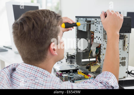 Young technician working on broken computer Stock Photo