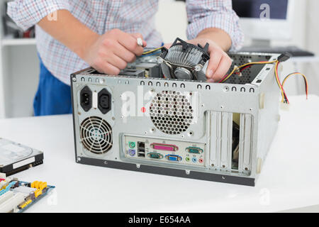 Young technician working on broken computer Stock Photo