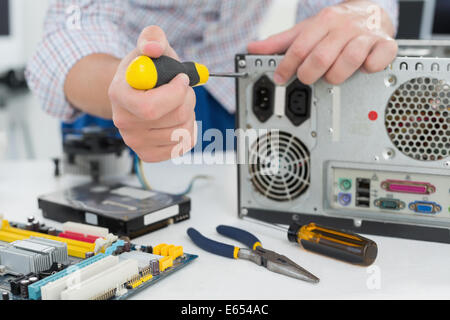 Young technician working on broken computer Stock Photo