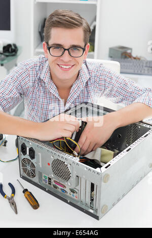 Young technician working on broken computer Stock Photo