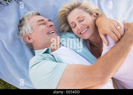 Happy senior couple cuddling on blanket Stock Photo