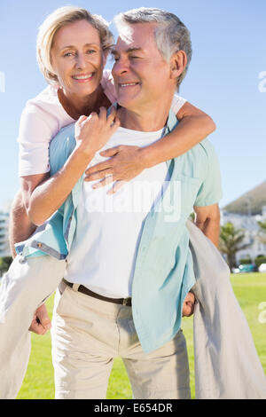 Happy senior man giving his partner a piggy back Stock Photo
