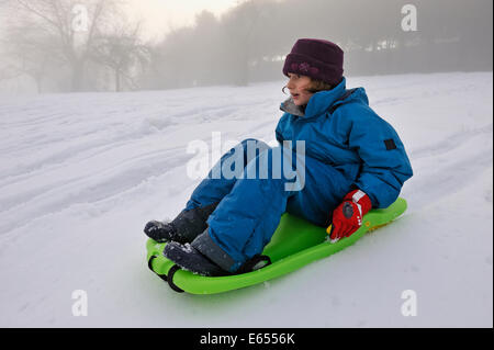 Little girl sledging in winter Stock Photo