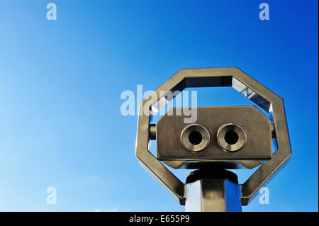 Binoculars or telescope looking up at a clear blue sky Stock Photo