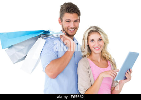 Attractive young couple holding shopping bags using tablet pc Stock Photo