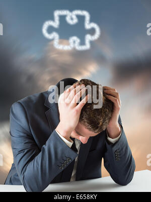 Composite image of businessman with head in hands Stock Photo