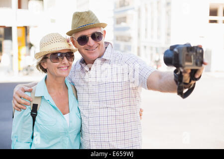 Happy tourist couple taking a selfie in the city Stock Photo