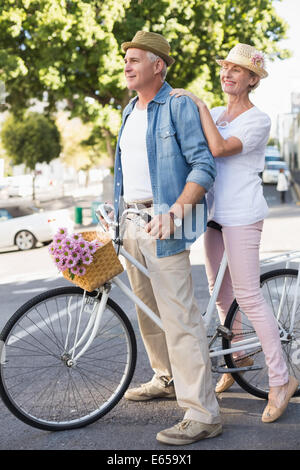 Happy mature couple going for a bike ride in the city Stock Photo