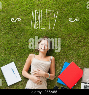Ability against pretty student lying on grass Stock Photo