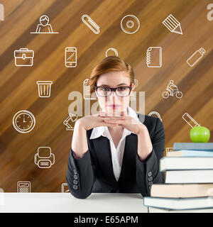 Composite image of redhead teacher sitting at desk Stock Photo