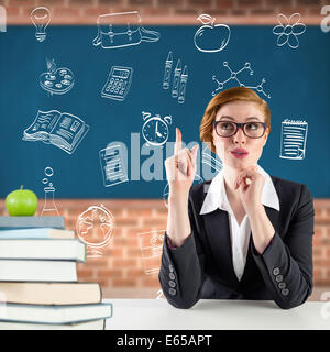 Composite image of thinking redhead teacher Stock Photo