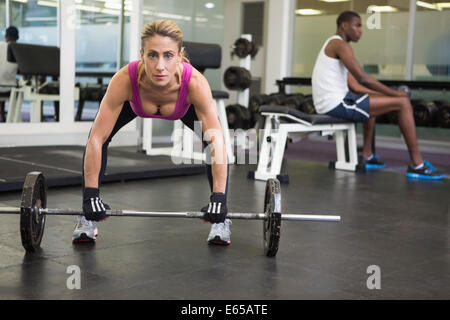 Fit young woman lifting barbell in gym Stock Photo