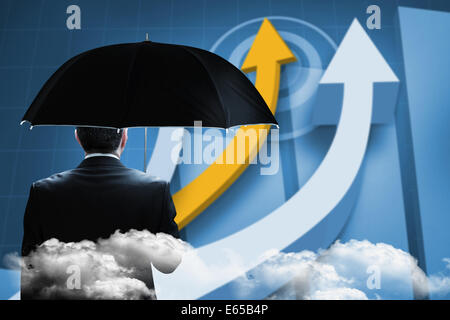 Composite image of mature businessman holding an umbrella Stock Photo