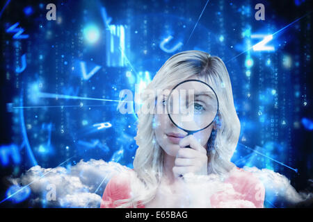 Composite image of fair-haired woman looking through a magnifying glass Stock Photo