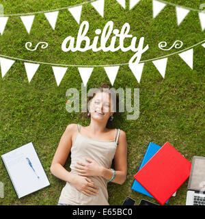 Ability against pretty student lying on grass Stock Photo