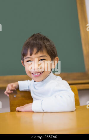 Cute pupil smiling at camera classroom with globe Stock Photo - Alamy
