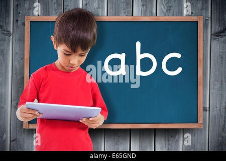 Composite image of cute boy using tablet Stock Photo