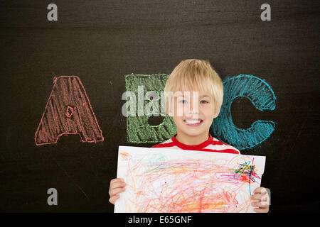 Composite image of cute boy showing his art