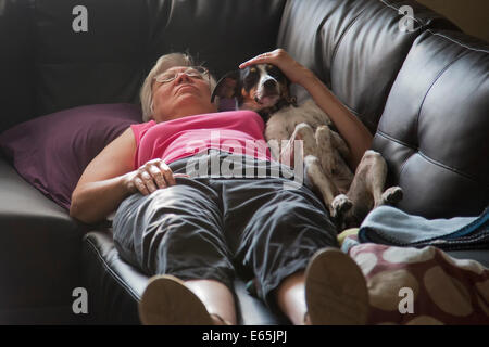 Denver, Colorado - Susan Newell, 65, takes a nap with dog Chloe. Stock Photo