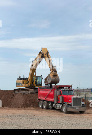 Excavator loads up a dump truck  on re-use pile for I-95 New Haven Harbor Crossing. Stock Photo