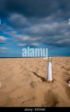 Message in a bottle on a sandy beach Stock Photo