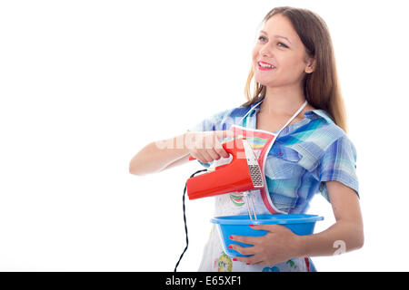 Young brunette female cook playfully prepares food using kitchen utensils Stock Photo