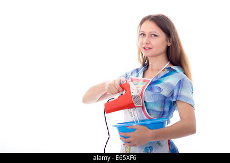 Young brunette female cook playfully prepares food using kitchen utensils Stock Photo