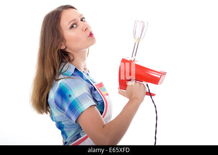 Young brunette female cook playfully prepares food using kitchen utensils Stock Photo