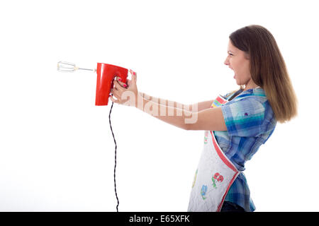 Young brunette female cook playfully prepares food using kitchen utensils Stock Photo