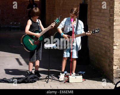 Two Children Busking on the streets of Cirencester, Gloucestershire, UK Stock Photo