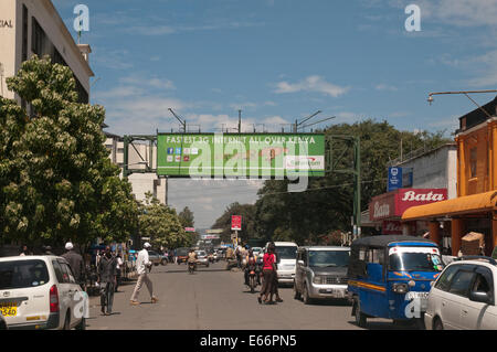 People and traffic on Kenyatta Avenue Nakuru Kenya East Africa with advertising hoarding for 3g Network Stock Photo