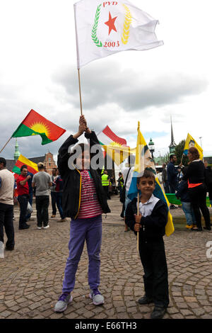 Copenhagen, Denmark – August 16th, 2014: Kurds demonstrates in front of the Danish parliament in Copenhagen against ISIS (Islamic State) warfare and atrocities in Iraq.  On the photo a girl holds the flag of PYD (Democratic Union Party) from northen Syria. PYD is affiliated with PKK. Credit:  OJPHOTOS/Alamy Live News Stock Photo