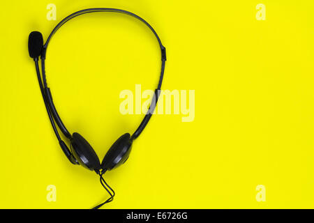 Microphone headset/headphones on a solid yellow background. Stock Photo