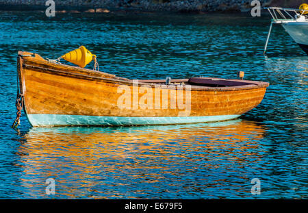 Brightly varnished small fishing boat moored in sparkling waters of Quarantine Bay, Eden, NSW Australia Stock Photo