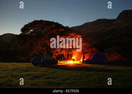 orange glow of a brightly burning camp fire at night Stock Photo