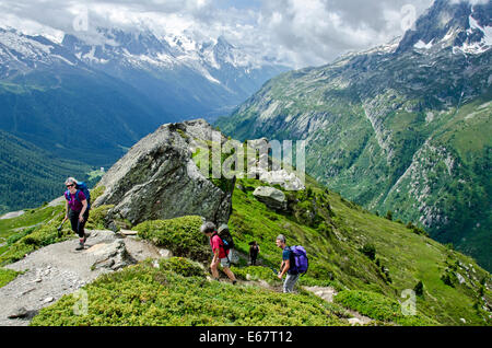 Walkers on the path from Le Tour up to the L' Aiguillettes des Possettes with the Chamonix valley in the background. Stock Photo