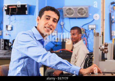 Student setting up generator experiment while student in wheelchair examines HVAC system Stock Photo