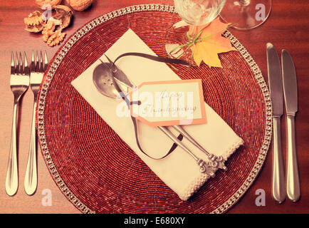 Beautiful Autumn Fall theme Thanksgiving dinner table place setting with Happy Thanksgiving tag attached to silverware. Stock Photo
