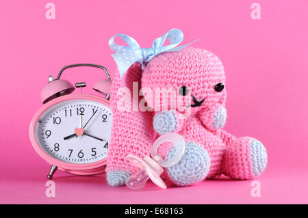 Baby girl nursery cute bunny toy, dummy pacifier and clock for on pink background baby shower or newborn girl greeting card. Stock Photo