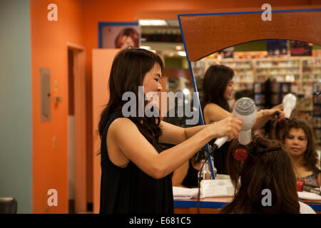 Vietnamese hairdresser working on her client's hair, Westminster, Orange County, California, USA Stock Photo